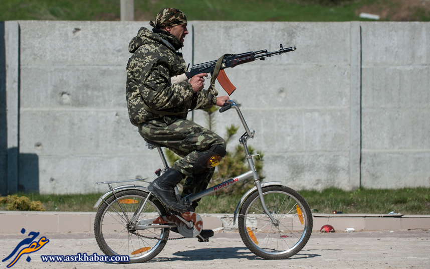 شلیک کلاشینکف با دوچرخه (عکس)