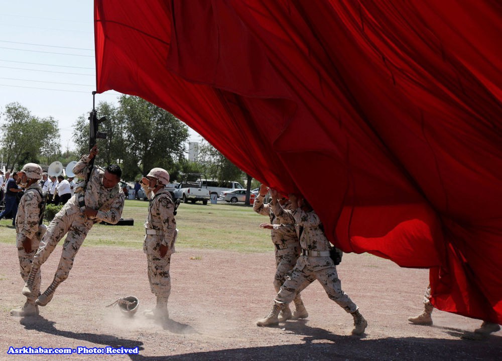 سرباز مکزیکی در حال نگهداشتن پرچم غول پیکر(عكس)