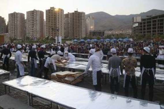 توزیع بزرگ ترین کیک جهان اسلام در کنار دریاچه شهدای خلیج فارس (+عکس)