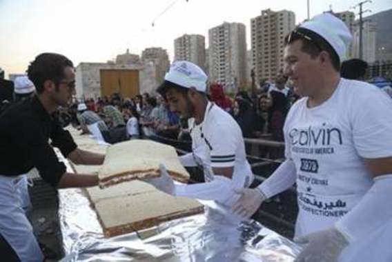 توزیع بزرگ ترین کیک جهان اسلام در کنار دریاچه شهدای خلیج فارس (+عکس)
