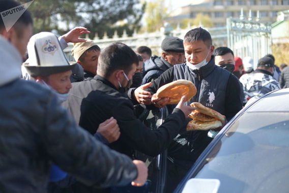 اهدای نان به شرکت کنندگان در راه پیمایی در نزدیکی هتل «ایسیک کول» در بیشکک
