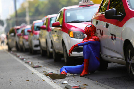 مردی با لباس مرد عنکبوتی کنار تاکسی در تظاهرات تاکسی ها علیه برنامه های درخواست تاکسی اینترنتی در مکزیک
